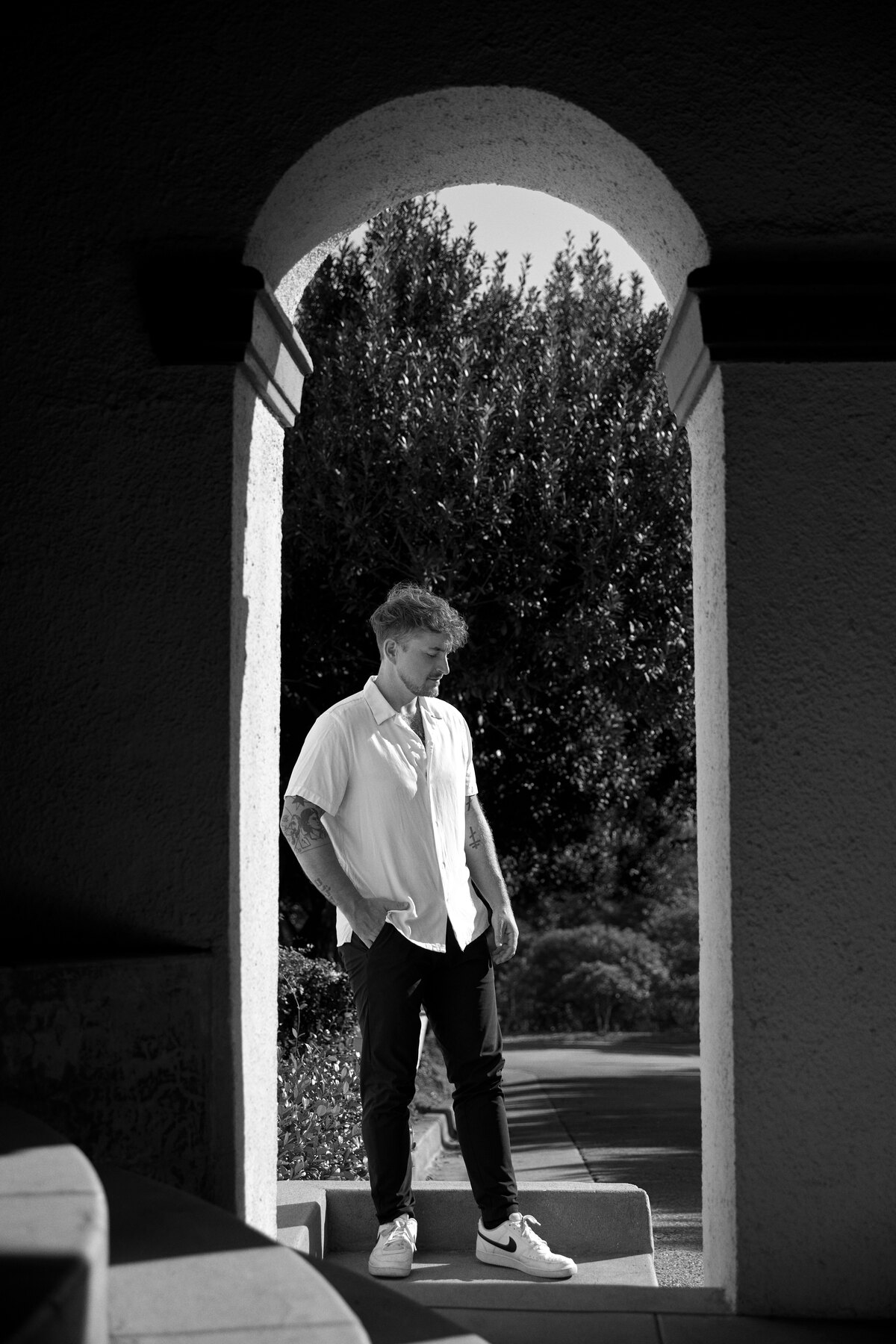 Dustin Kuhns standing beneath an architectural archway.