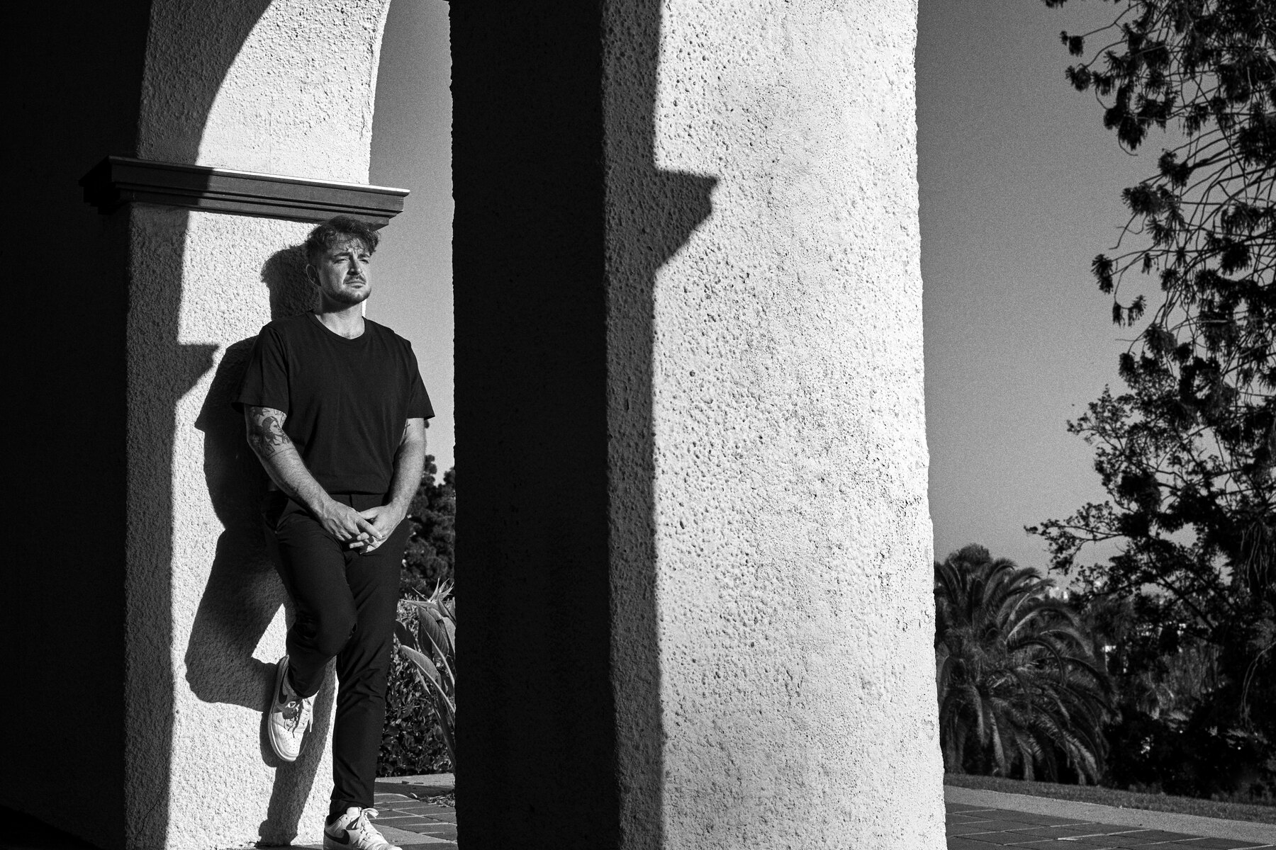 Dustin Kuhns standing within a hard-shadowed architectural space.