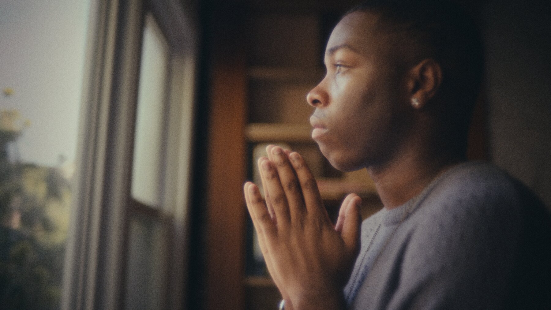 A young person looking through a window in In Need of Seawater.